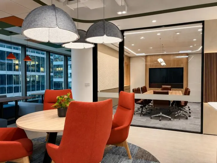 IOI Tower: breakout area with orange chairs beside a glass-walled meeting room